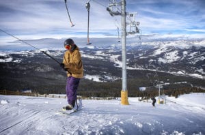 Snowboarder on Poma lift at Copper Mountain