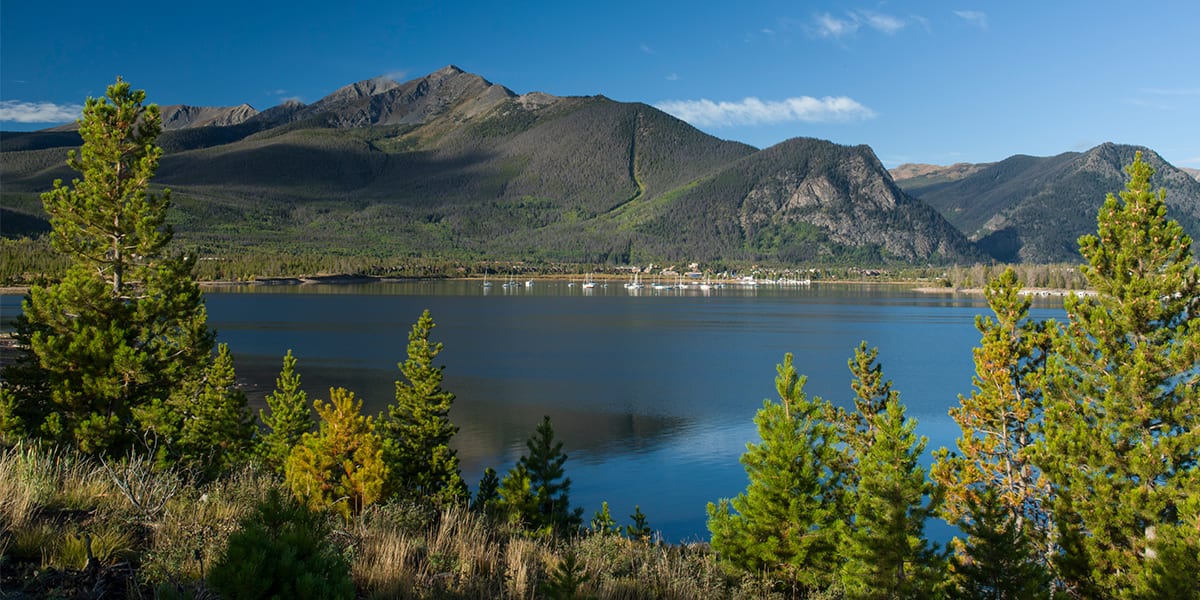 View of Dillon Reservoir with the Ten Mile Mountain Range and trees in the foreground