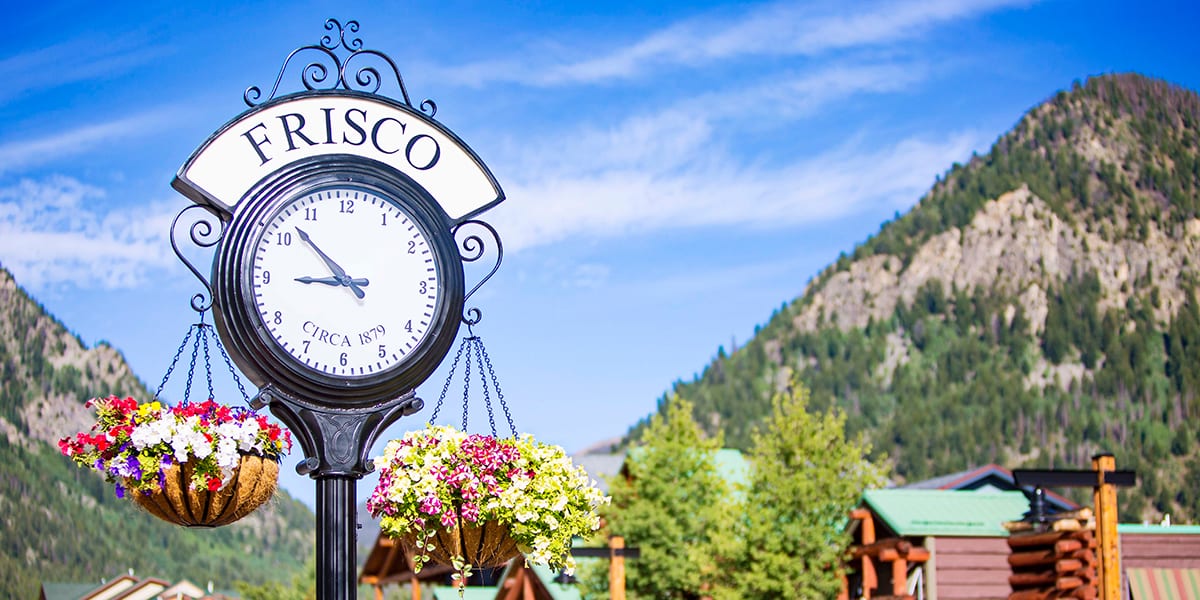 Frisco clock on Main Street with hanging flower baskets