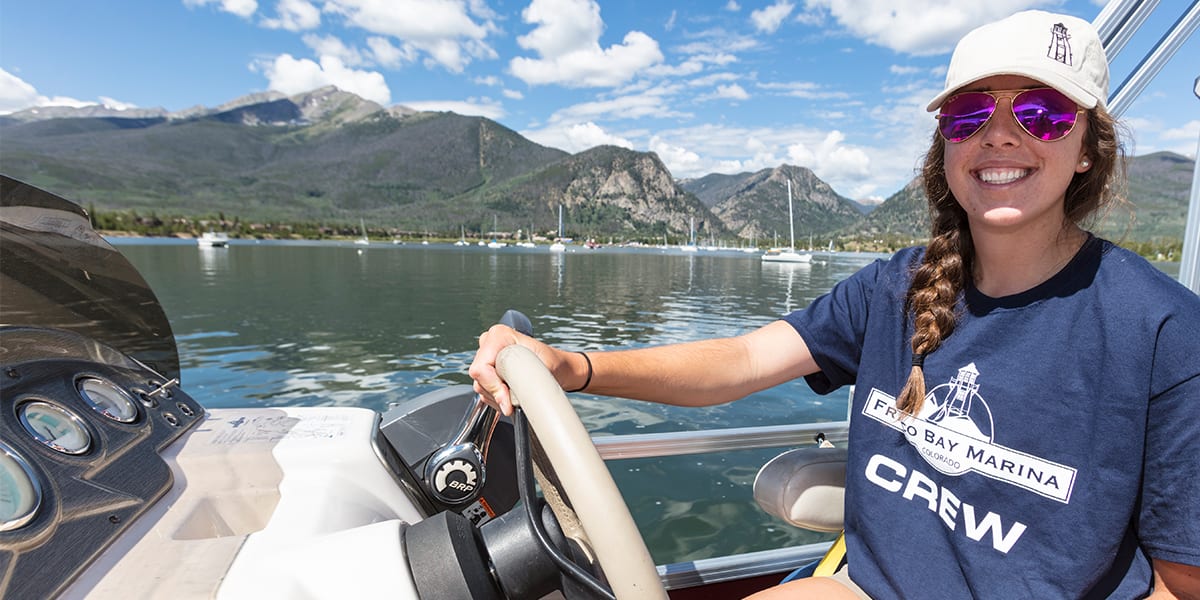 A Frisco Bay Marina staff person steering a powerboat on Dillon Reservoir
