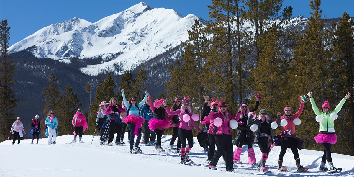Group of people dressed in pink snowshoeing at Snowshoe for the Cure event