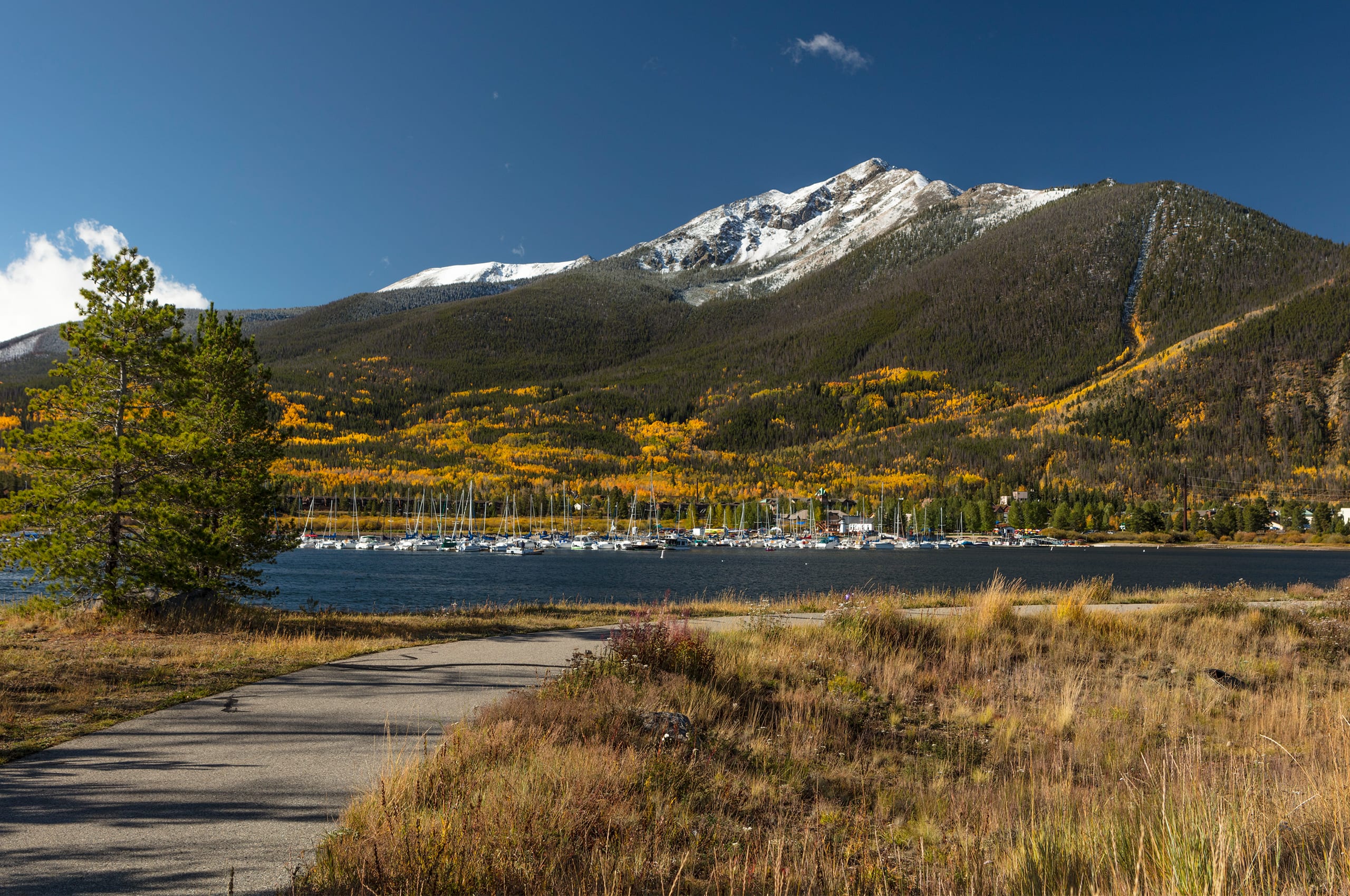 Recreation path in Frisco with Dillon Reservoir and Ten Mile Range with snow
