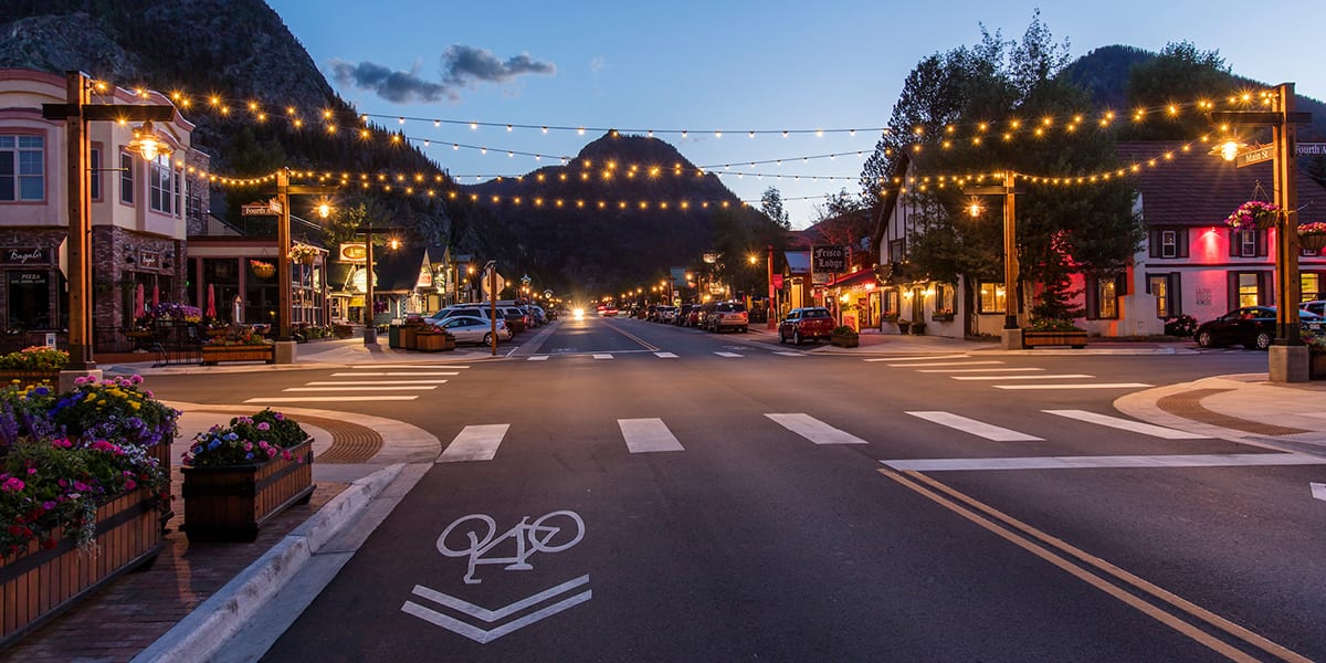 Frisco Main Street at 4th Avenue with string lights over the road at twilight in the summer