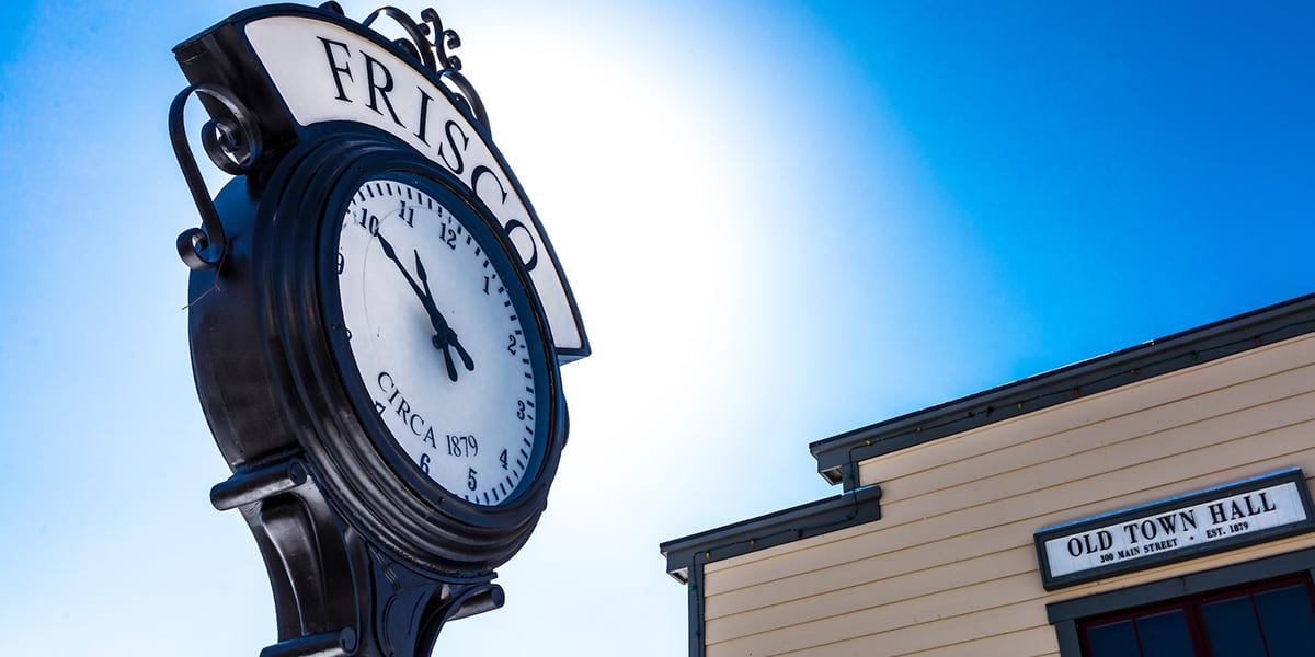 Frisco Clock with blue sky and the Frisco Information Center in the background