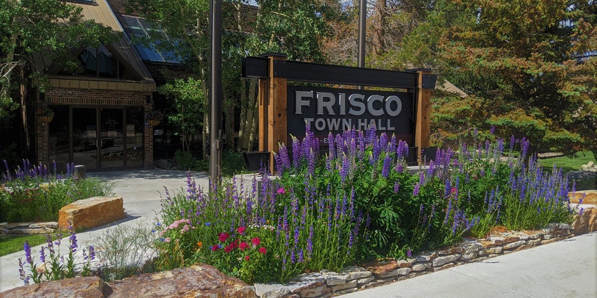 The Frisco Town Hall sign with mountain lupine flowers in front of it