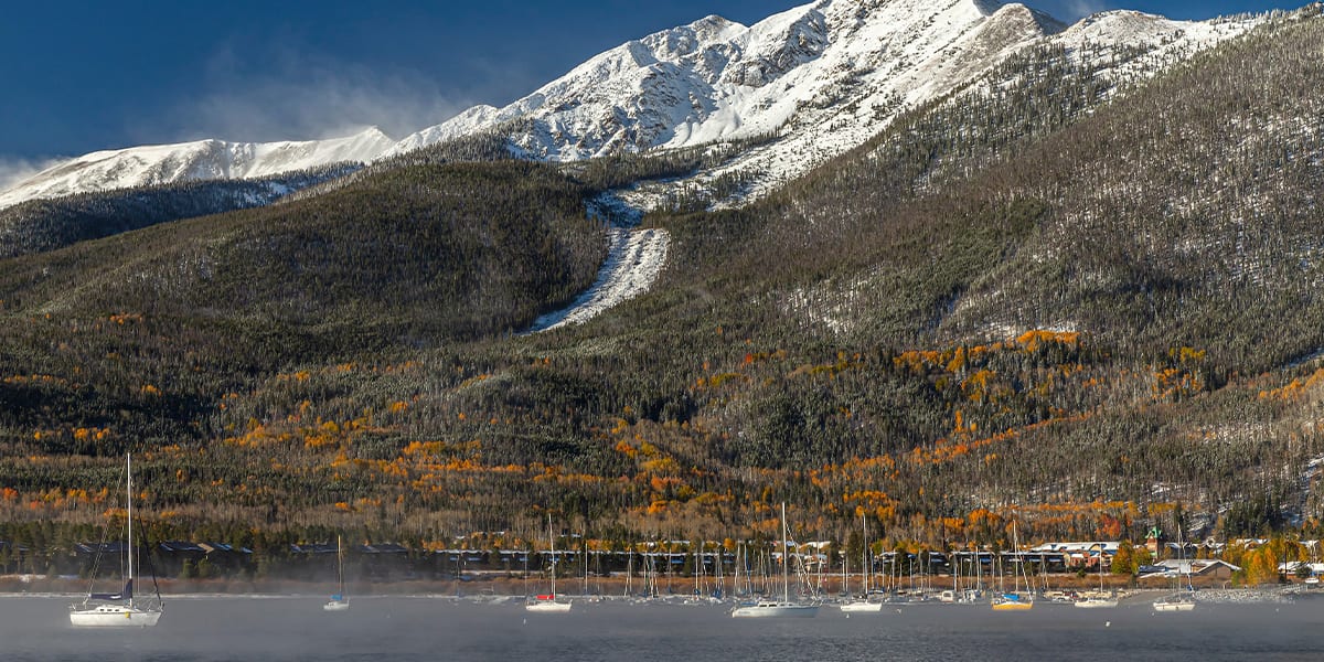 Peak One with snow and fall colors with Frisco Bay Marina and Dillon Reservoir in the foreground