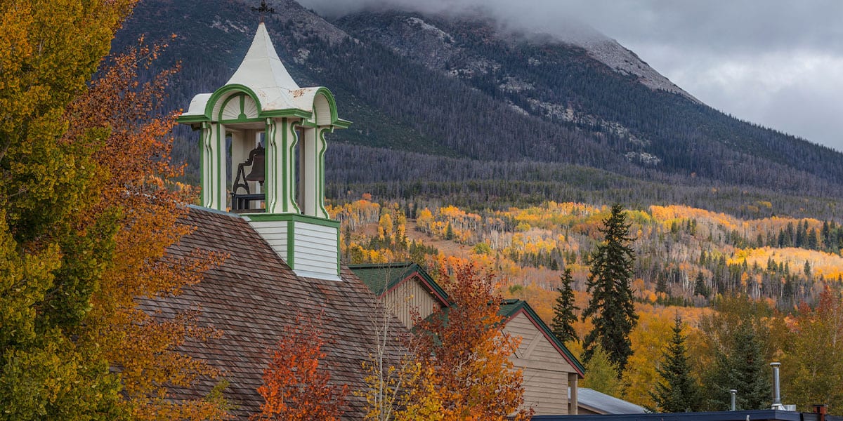 Closeup of top of Schoolhouse Museum with yellow and orange foliage