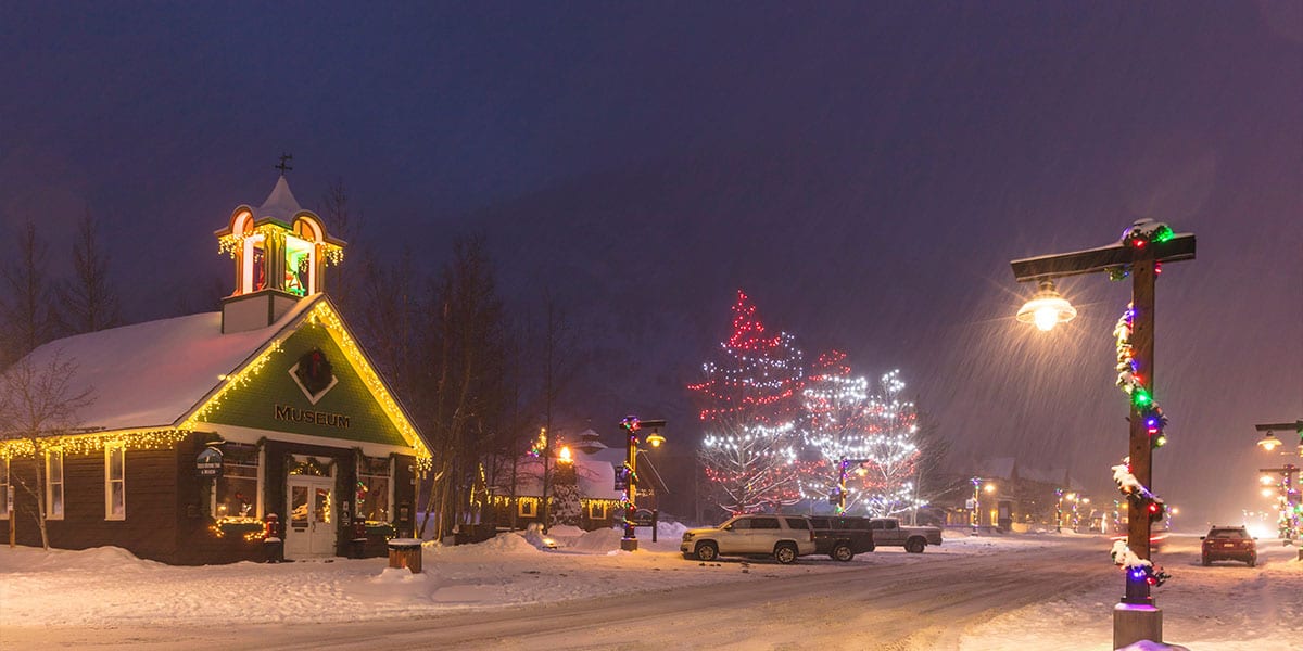 Winter view of Historic Park Museum and lit up trees on Main Street during a snow storm