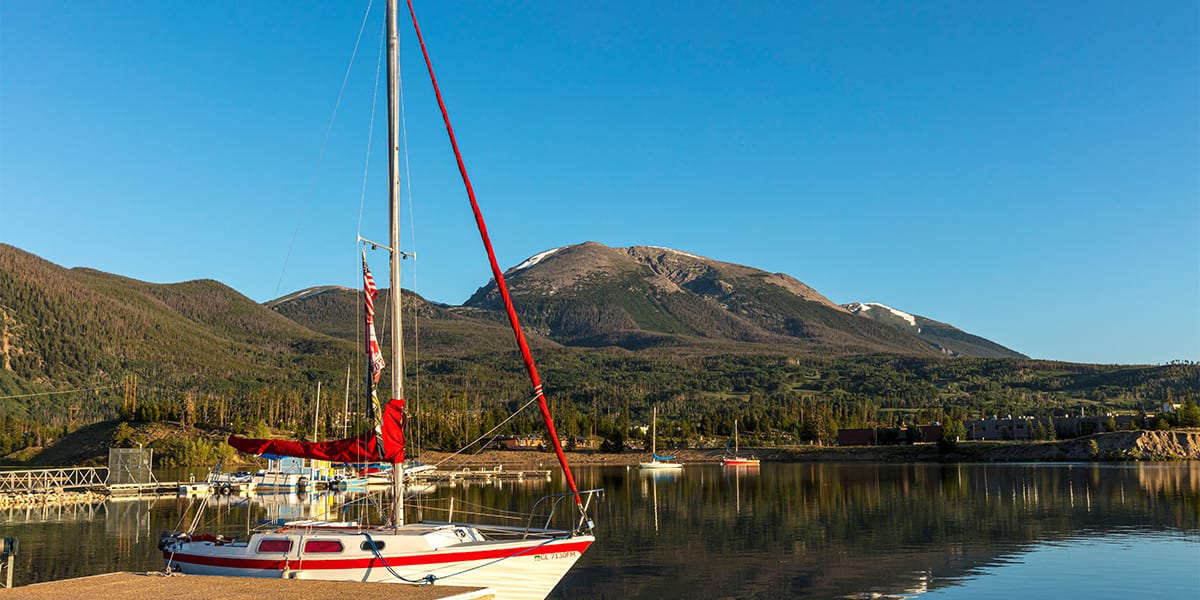 Red and white boat docked at Dillon Marina with Buffalo Mountain in the background