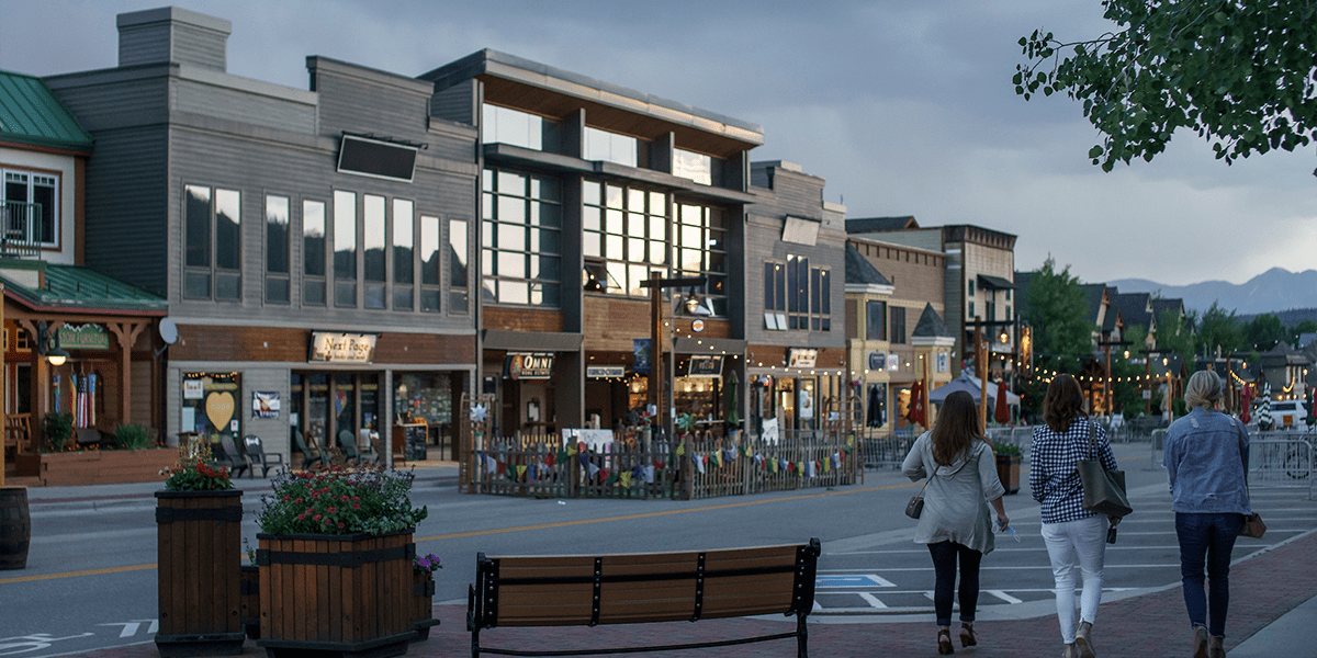 Main Street buildings at dusk, people walking.