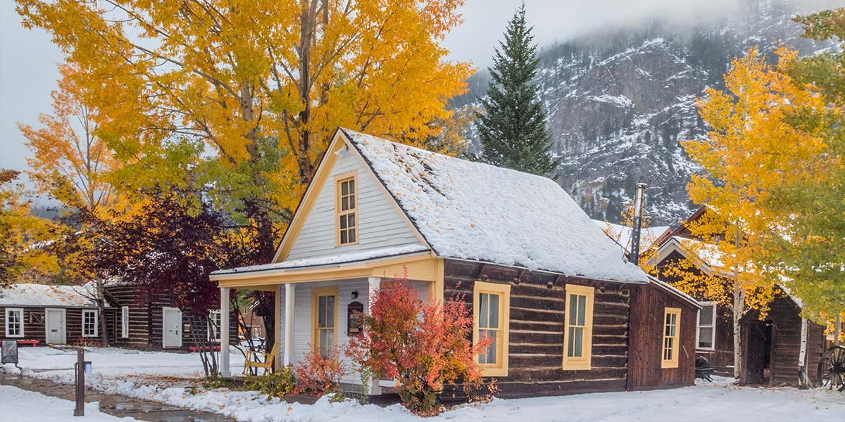 Cabin at Historic Park with snow and yellow cottonwoods