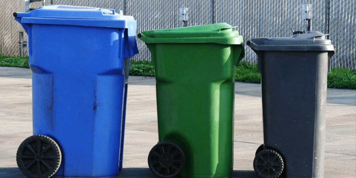 Three different sized trash cans lined in a row