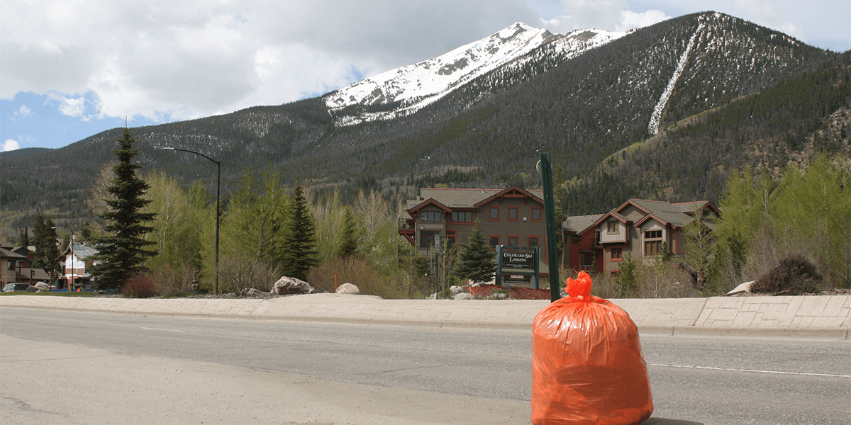 Orange trash bag on Summit Boulevard with Peak One in the background