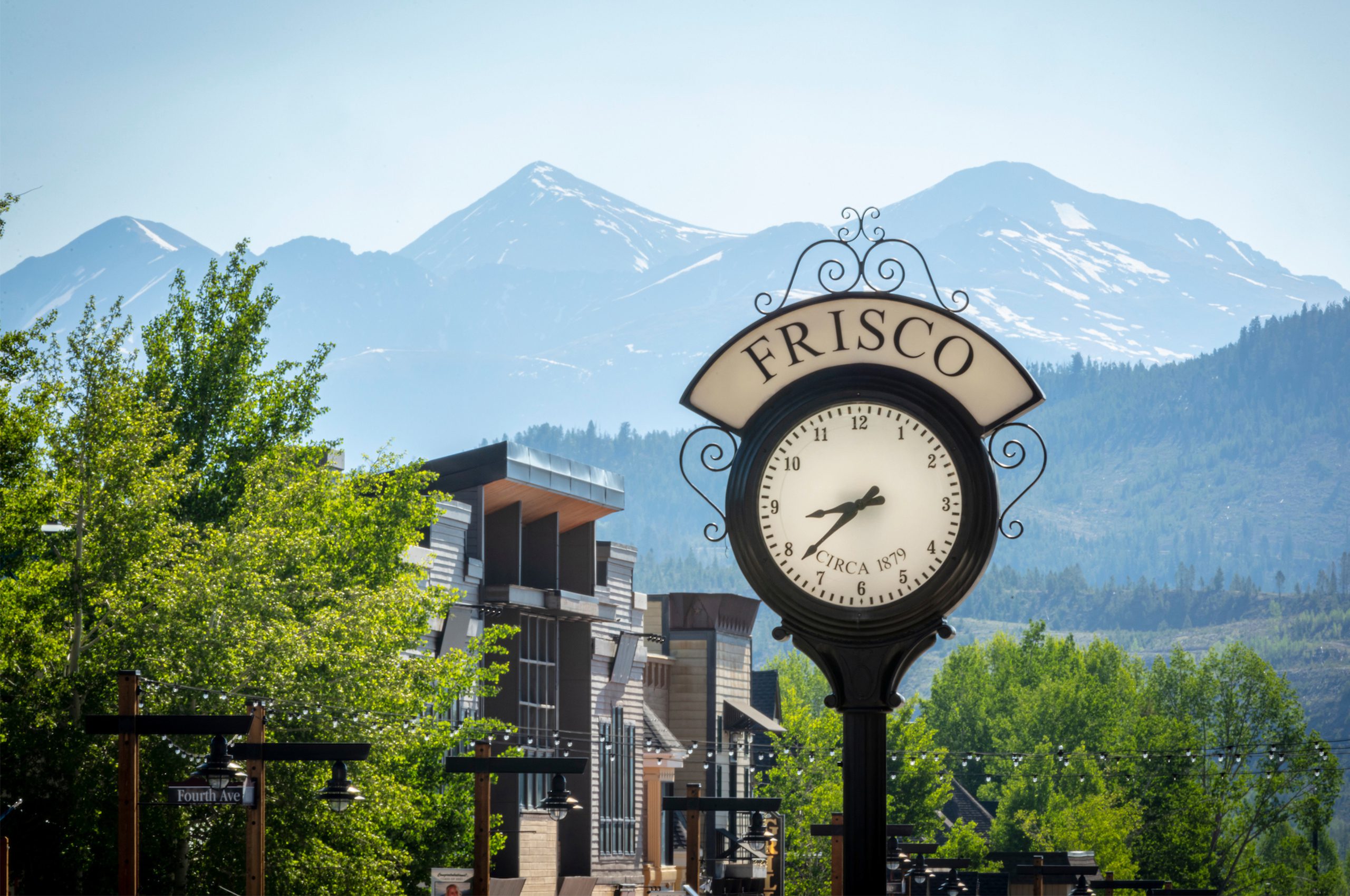 Frisco clock in the spring with green trees