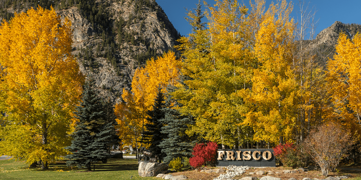 Frisco sign at Triangle Park against backdrop of yellow trees