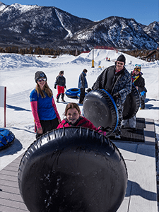 Family with tubes loading magic carpet