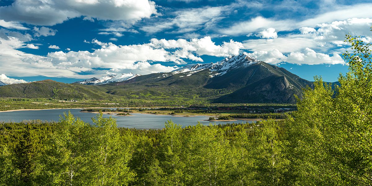View of Peak One with snow and Dillon Reservoir in spring