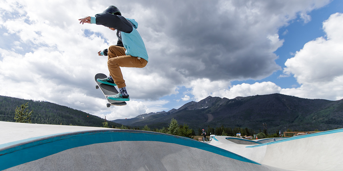 Boy on skateboard getting air in skate park at the Frisco Adventure Park